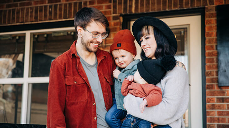 man and woman smiling at their child