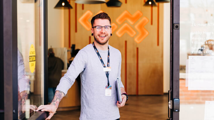 Canvas employee holding the door open for a member